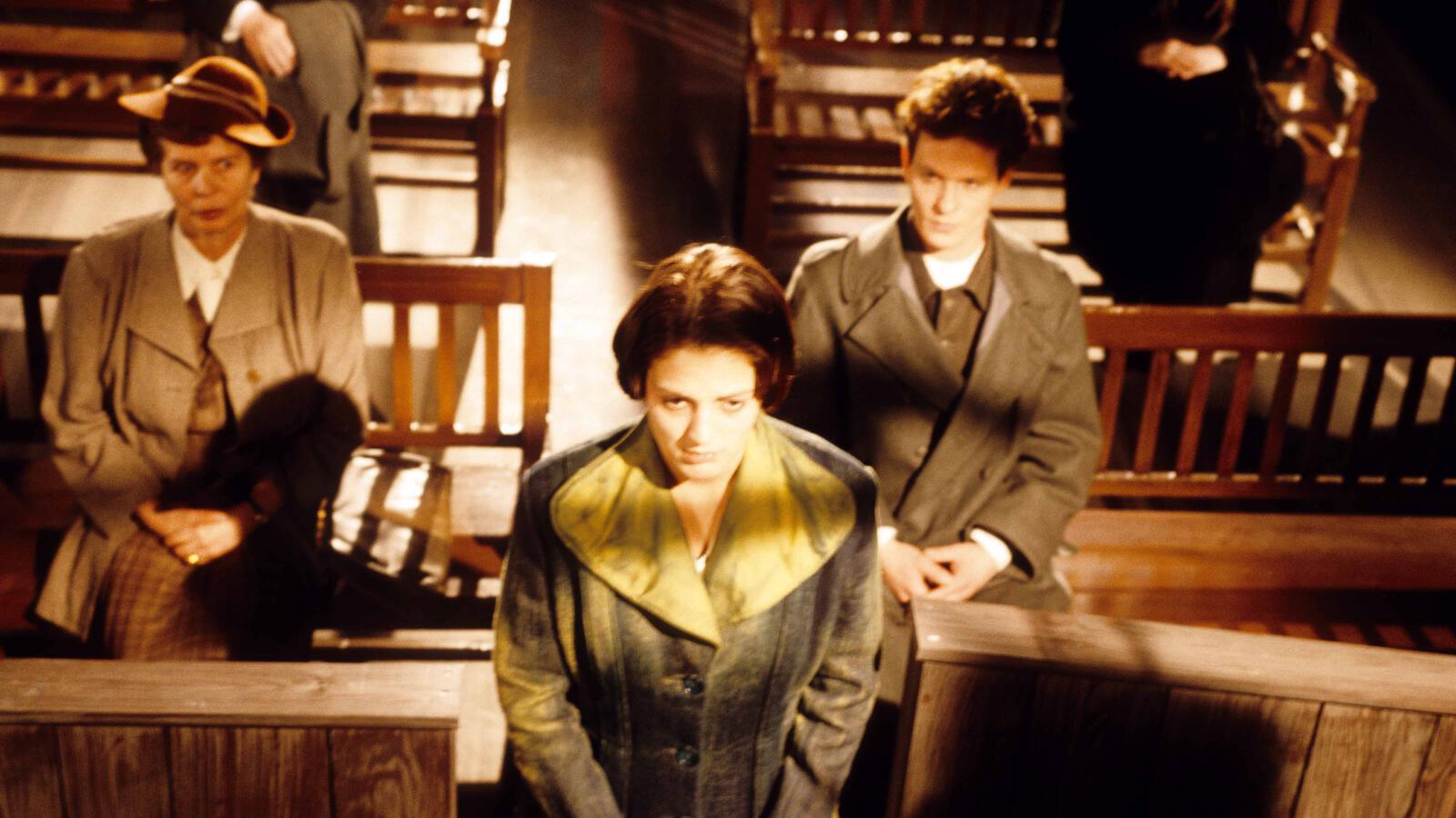 Frau mit gelbem Mantel schaut