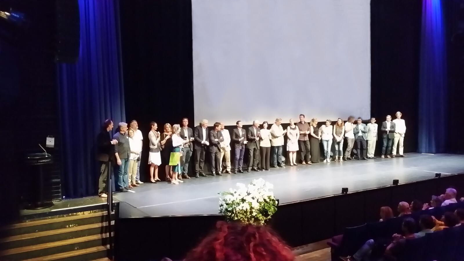 Premierenteam vor Leinwand